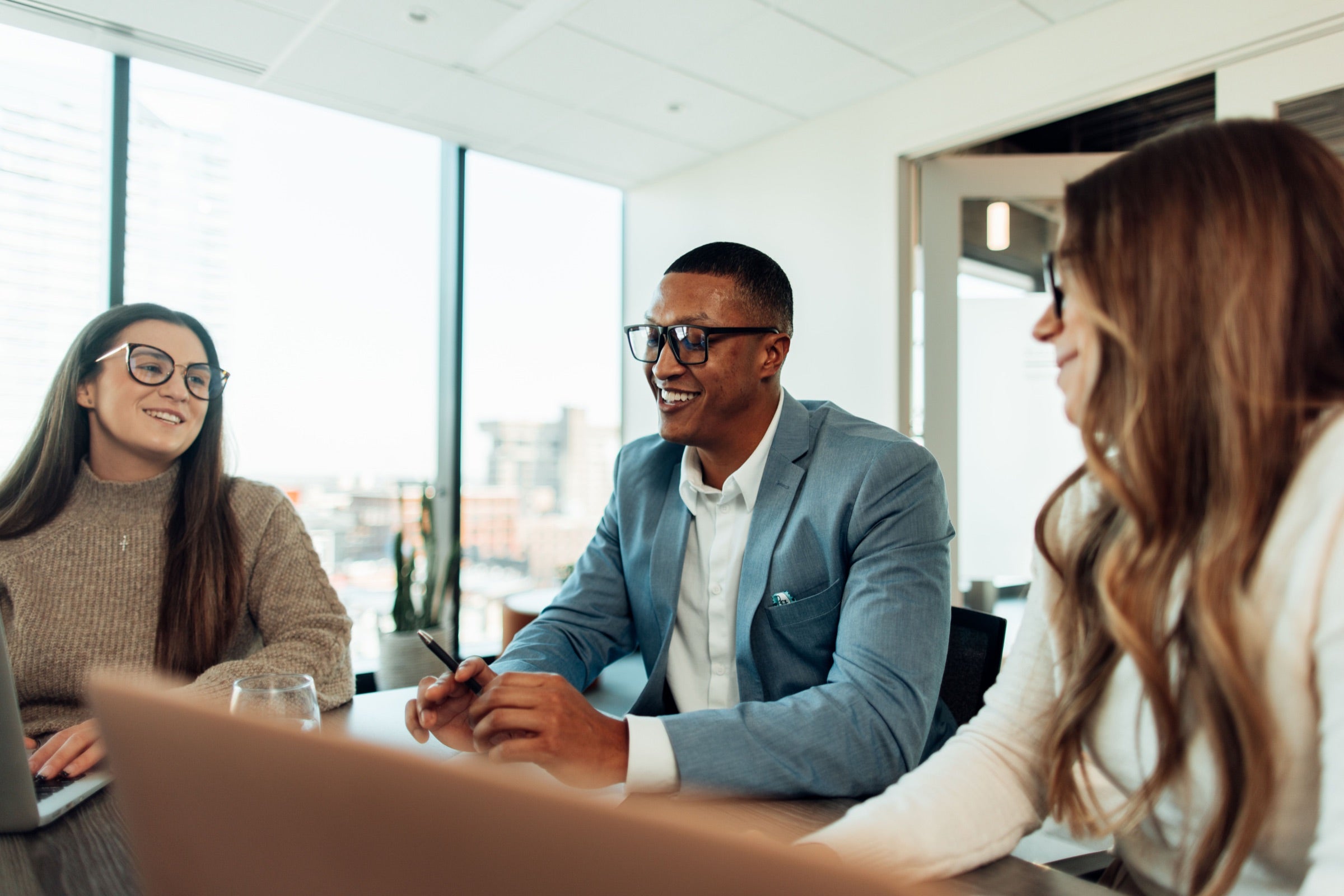 Team members wearing Bye Blue Light glasses in a conference room